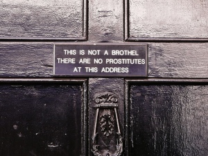 Image of an sign on a Soho door that states "This is not a brothel, no prostitutes live at this address"